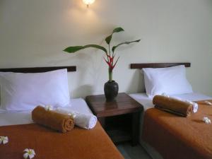 two beds in a room with a vase with a plant at Baan Lamai Resort in Lamai