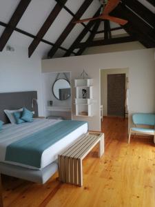Montebelo Milibangalala Bay Resort في مابوتو: غرفة نوم كبيرة مع سرير كبير وكرسي