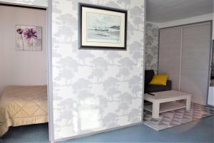 - une chambre avec un mur orné d'une peinture de nuages dans l'établissement Appartement 2-4 pers VUE MER EXCEPTIONNELLE avec terrasse à PERROS-GUIREC - Ref 908, à Perros-Guirec
