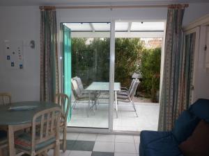 um quarto com uma mesa e cadeiras e uma porta de vidro em Villa climatisée 3 Pièces 100 m plage CAP D'AGDE em Cap d'Agde
