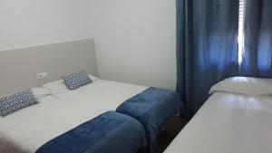 Łóżko lub łóżka w pokoju w obiekcie Hostal VILLA CARBULA