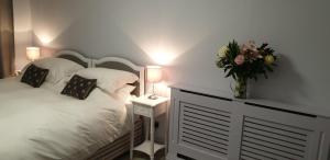 Un pat sau paturi într-o cameră la Maugersbury Park Suite