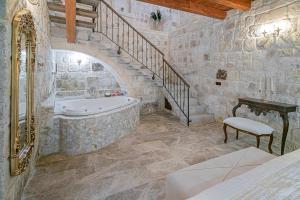 a stone bathroom with a tub and a staircase at Zeydem Suites in Urgup +189 photos
