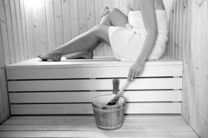 a woman sitting on top of a tub with a bucket at Odysseia Hotel Kapetanios in Limassol
