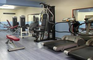 a gym with several tread machines and a mirror at Odysseia Hotel Kapetanios in Limassol