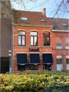 um edifício de tijolos com toldos pretos em B&B Toast Hoogstraten em Hoogstraten