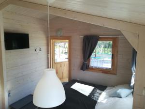 een slaapkamer met een bed in een houten huis bij Domki Letniskowe REJS in Ustronie Morskie