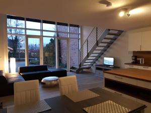 a living room with a black couch and a staircase at WH Boardinghouse in Papenburg