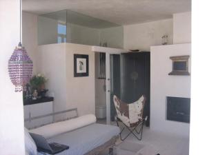 ein Wohnzimmer mit einem Sofa und einem Stuhl in der Unterkunft Apartamentos Casa del Coronel in Tarifa