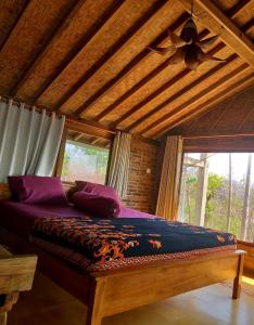 duże łóżko w pokoju z drewnianym sufitem w obiekcie Batu Hill Villa w mieście Watukarung