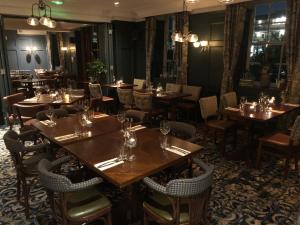 a restaurant with tables and chairs in a room at The Greyhound Inn in Gerrards Cross