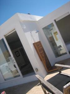ein weißes Haus mit Glastüren und einem Stuhl in der Unterkunft Apartamentos Casa del Coronel in Tarifa