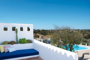 a balcony with a blue bench next to a swimming pool at La Masía de Formentera in Sant Francesc Xavier