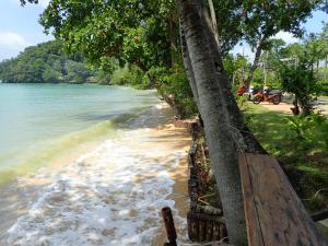 a beach with a tree next to the water w obiekcie Laguna Villas Boutique Hotel w mieście Ko Yao Noi