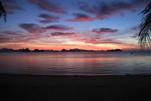 una puesta de sol sobre un cuerpo de agua con una playa en Laguna Villas Boutique Hotel, en Ko Yao Noi