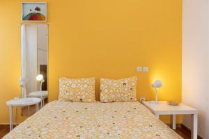 a bedroom with a bed with a yellow wall at So Athens - Charming 1BD flat, Large terrace, Acropolis view in Athens