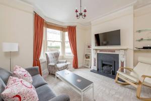 a living room with a couch and a fireplace at Spacious House - 2 Double Rooms - Street Parking - Garden in Bath