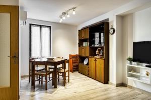 une salle à manger avec une table et une télévision dans l'établissement Casa Raffaele, à Malcesine