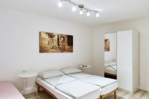 - une chambre blanche avec un lit et un miroir dans l'établissement Casa Raffaele, à Malcesine