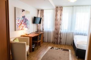 a hotel room with a desk and a bed at Hotel Bürger in Siegen