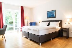 ein Hotelzimmer mit einem Bett und einem großen Fenster in der Unterkunft Hotel Bürger in Siegen