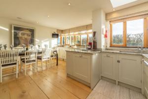 a kitchen and dining room with a table and chairs at Higher Close in Mawgan Porth