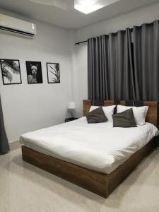 1 dormitorio con 1 cama grande con sábanas blancas en Betong Cozy Guesthouse เบตง โคซี่ เกสต์เฮาส์, en Betong
