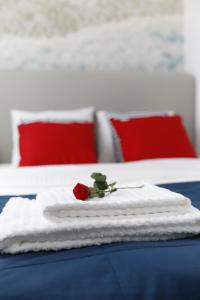 a red rose sitting on a pile of towels on a bed at Apartament w Centrum in Słupsk
