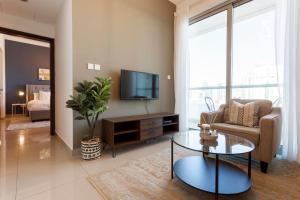a living room with a tv and a couch and a table at GuestReady - Modern Apartment with Gorgeous Views in Dubai