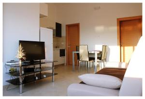 a living room with a couch and a table with a tv at Apartments Dirsi in Trogir