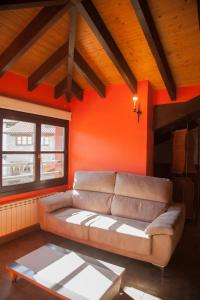 een woonkamer met een bank en een rode muur bij Los Picos in Porrúa