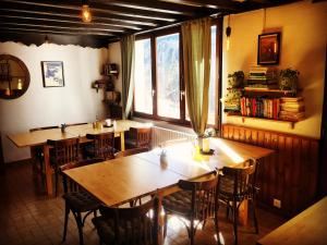 een restaurant met houten tafels en stoelen en een raam bij Hotel Au Bon Accueil in Les Deux Alpes