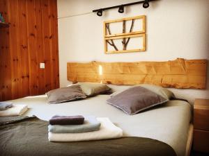 a bed with two pillows and towels on it at Hotel Au Bon Accueil in Les Deux Alpes