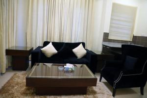 a living room with a couch and a coffee table at Butterfly Guest House Phase 7 Bahria Town in Rawalpindi