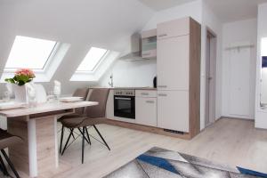 une cuisine avec des appareils électroménagers blancs et une table avec des chaises dans l'établissement T&K Apartments near Messe Fair Trade Düsseldorf und Airport 3A, à Duisbourg