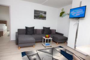 a living room with a couch and a flat screen tv at T&K Apartments near Messe Fair Trade Düsseldorf und Airport 3A in Duisburg