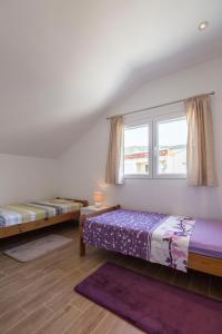 a bedroom with two beds and a window at Vanja in Komiža