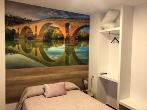 a bedroom with a painting of a bridge at Pensión Mavi in Los Arcos