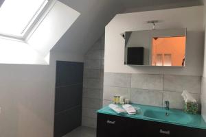 un bagno con un lavandino verde e uno specchio di la petite loge ad Ay