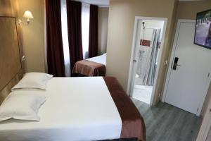 Vuode tai vuoteita majoituspaikassa Hotel Phenix