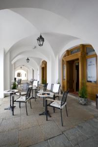 un groupe de tables et de chaises dans un bâtiment dans l'établissement Hostel U Zlatého kohouta, à Kroměříž