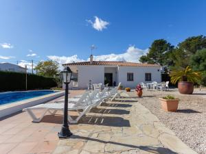 a row of white lounge chairs next to a pool at INNOUTHOME Gran casa con piscina Virgen Cinta II in L'Ametlla de Mar