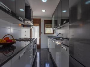 a kitchen with white appliances and a bowl of fruit on the counter at INNOUTHOME Gran casa con piscina Virgen Cinta II in L'Ametlla de Mar