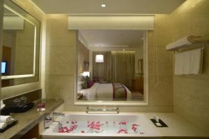 a bathroom with a bath tub with a large mirror at InterContinental Jaipur Tonk Road, an IHG Hotel in Jaipur