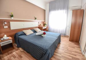 a bedroom with a blue bed with flowers on it at Miramare Inn Hotel in Marotta