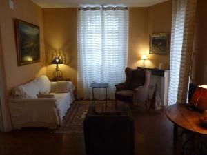 a living room with a couch and chairs and a window at Appartement Petite Saunerie in Avignon