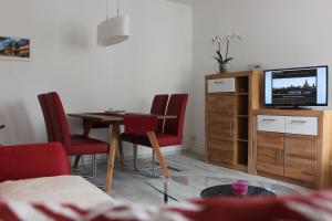 un soggiorno con tavolo, sedie e TV di Weber Apartments a Dresda