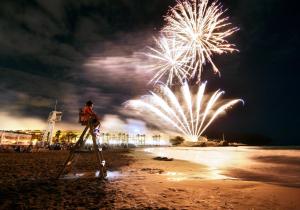 a person on a ladder watching fireworks on the beach at La Sort Boutique Hotel in Moraira
