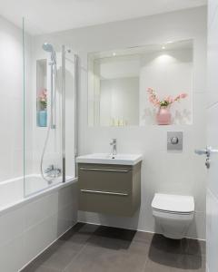 uma casa de banho com um WC, um lavatório e um chuveiro em Queens Park by Viridian Apartments em Londres
