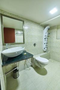 a bathroom with a sink and a toilet and a mirror at Aureole Mrida - A Boutique Hotel in Lonavala